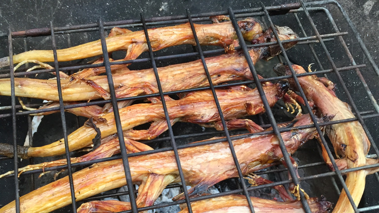 Grilled iguana under metal racks