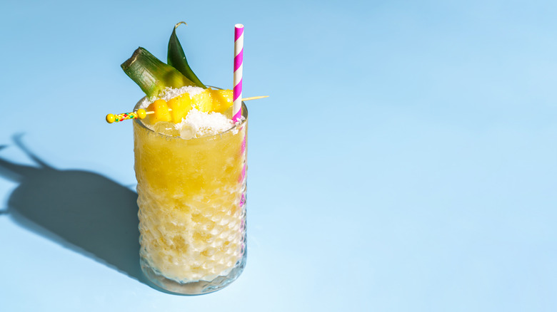 Pineapple cocktail with striped straw