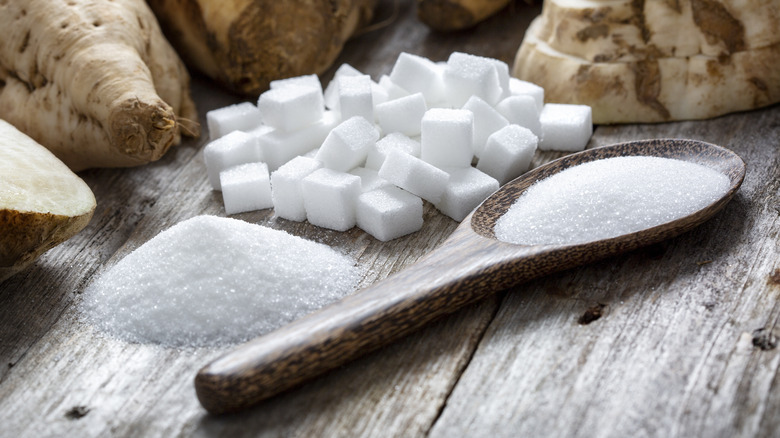 White sugar and sugar cubes with wooden spoon