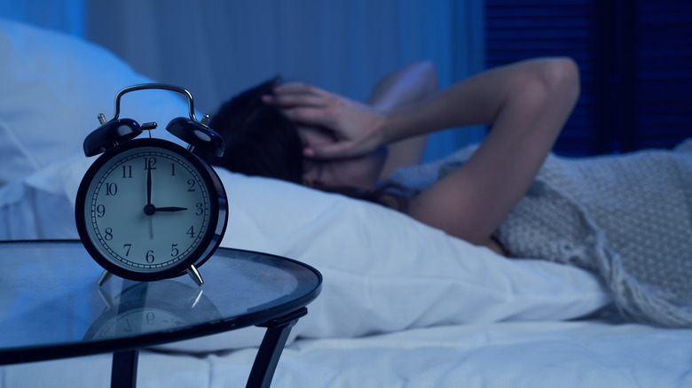 Alarm clock and person in bed