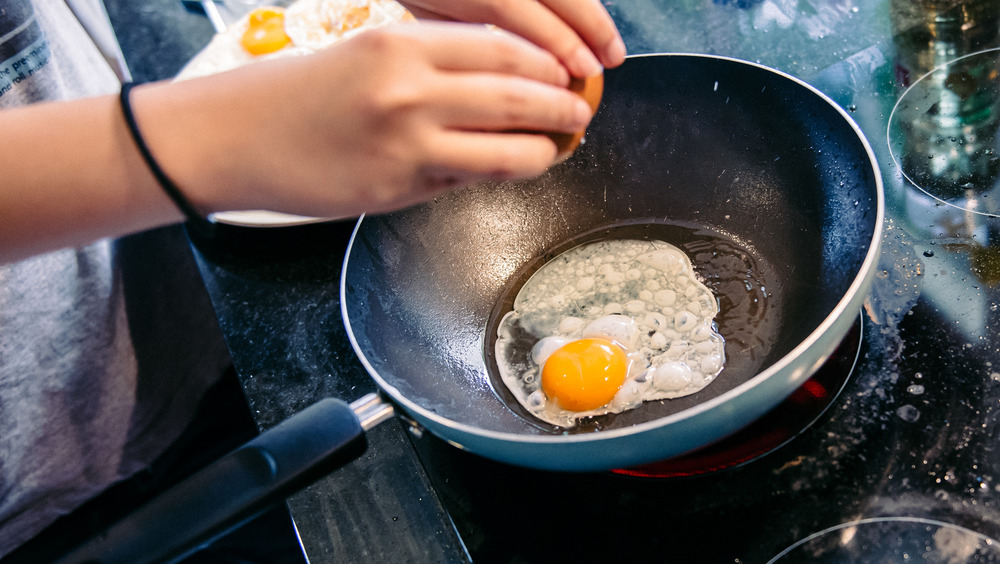 cracking egg into frying pan