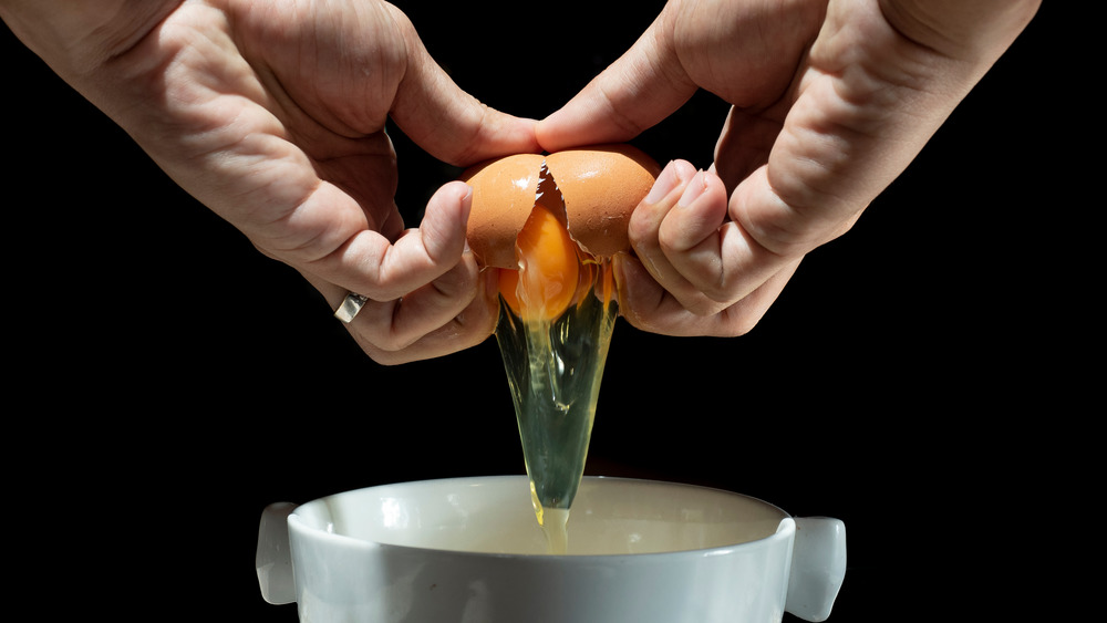 Chef's hands cracking egg