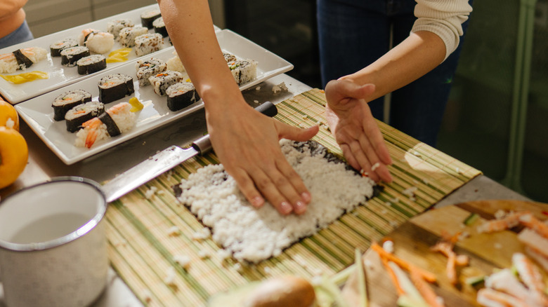 Two people making homemade sushi