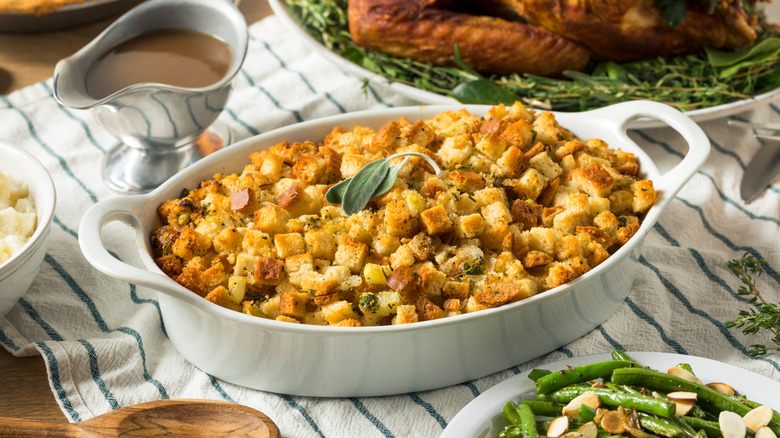 Stuffing in dish with a sprig of rosemary on Thanksgiving table