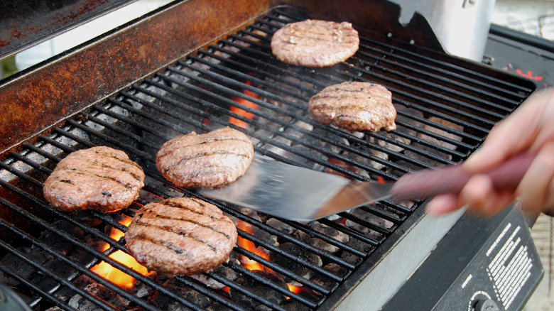 flipping burgers on grill