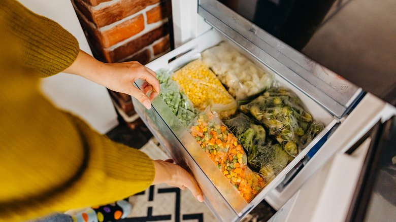 Woman taking food from home freezer