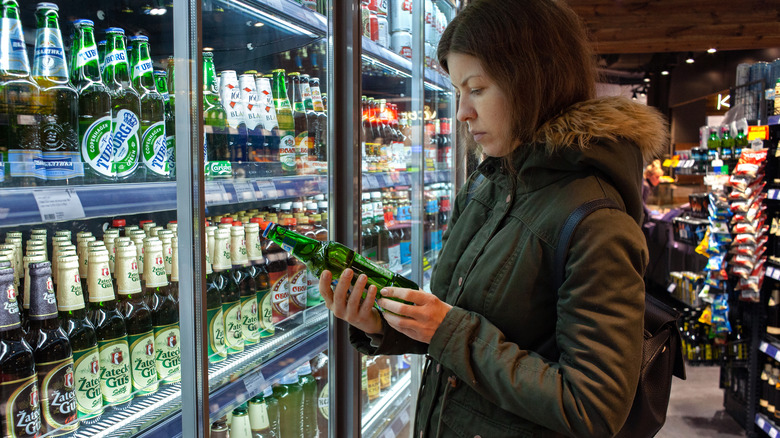 person reading beer bottle label