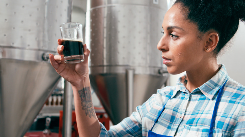 woman inspecting beer