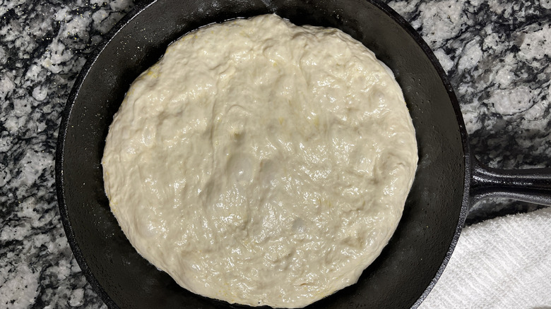 pizza dough stretched in cast iron skillet