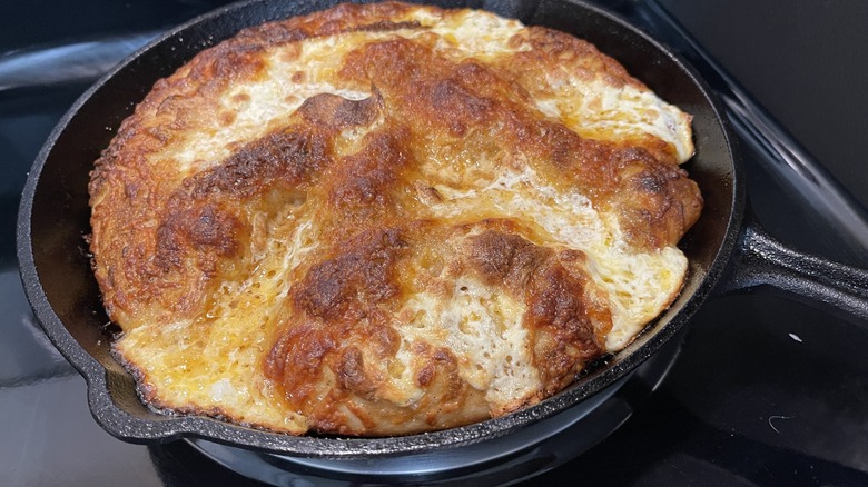 baked golden cheesy pizza in skillet