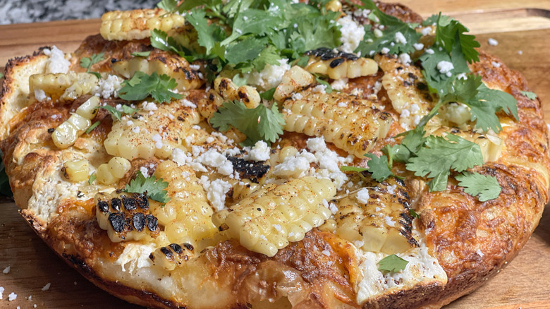 cheesy elotes street corn pizza on cutting board