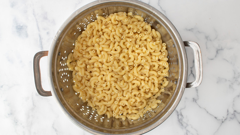 elbow macaroni in colander