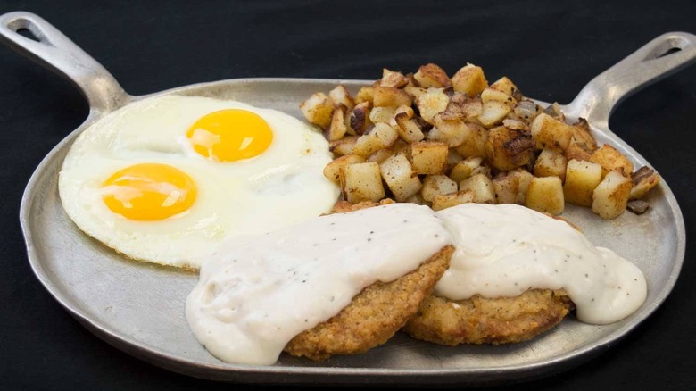 A skillet of eggs, hashbrowns, and sausage