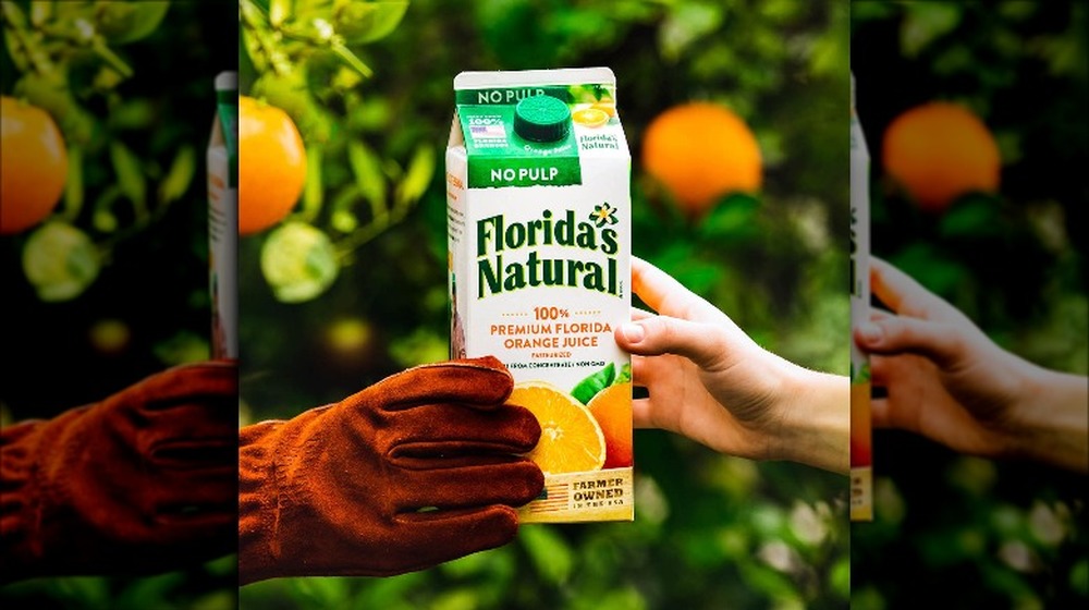 hands passing Florida's Natural orange juice