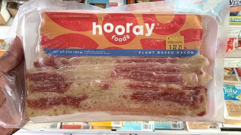 hand holding package of Hooray bacon