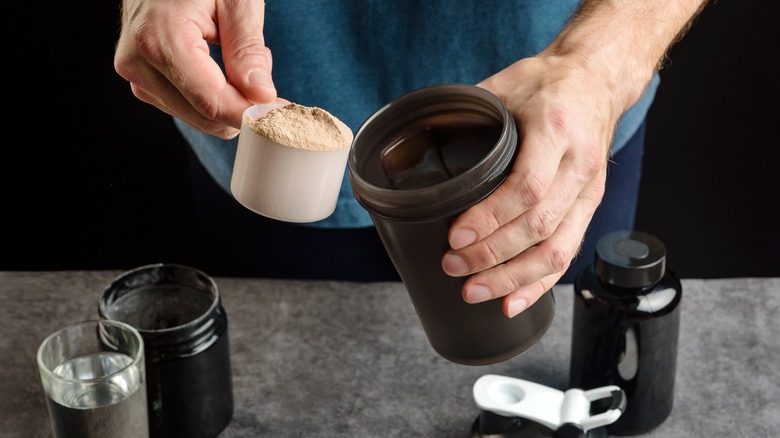 Man adding protein shake powder into bottle