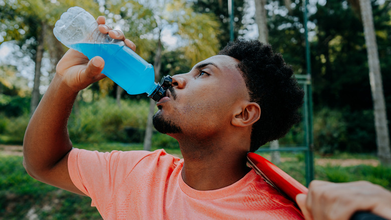 Man drinking blue sports drink