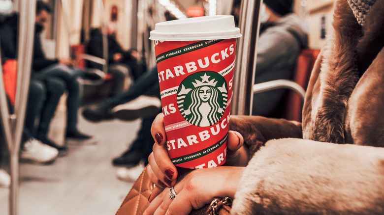 subway passenger holding Starbucks cup