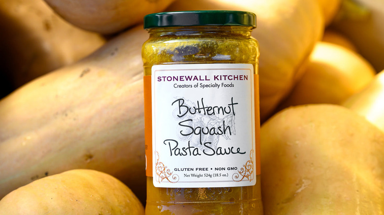 a jar of stonewall kitchen butternut squash pasta sauce surrounded by butternut squashes