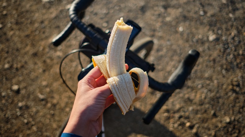 Hand holding banana over bike