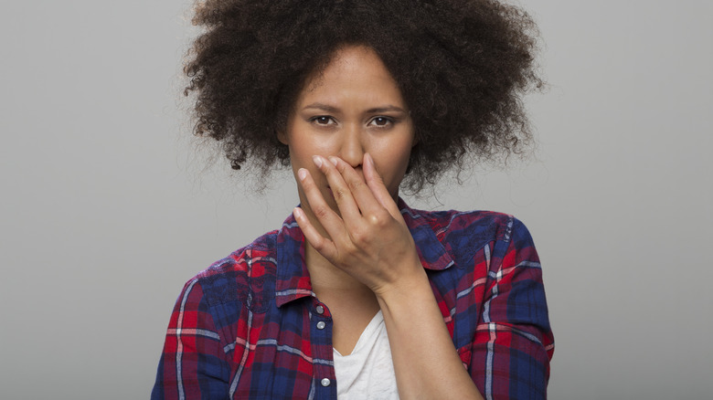 young woman holding her nose