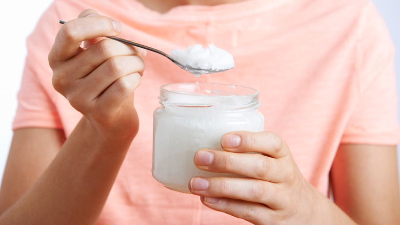 spooning coconut oil out of jar