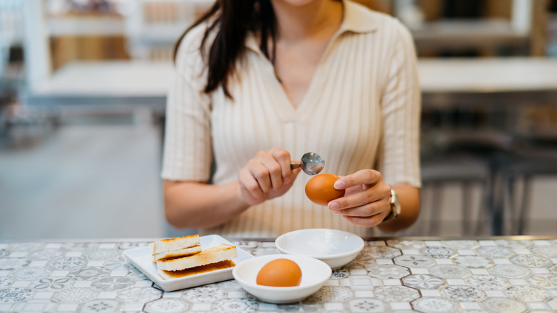 Woman eating an egg