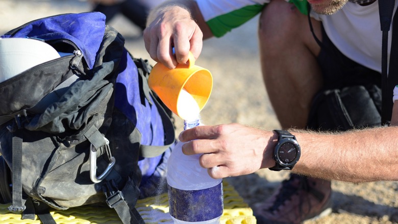 man pouring electrolytes into water