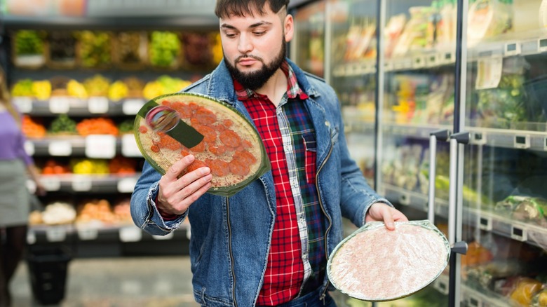 Man looking at frozen pizza