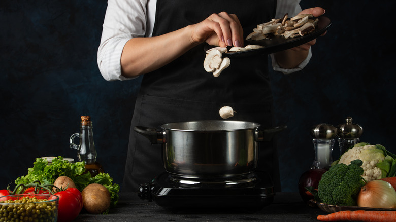 cbest coking bethef slicing and cooking mushrooms in a pot of water