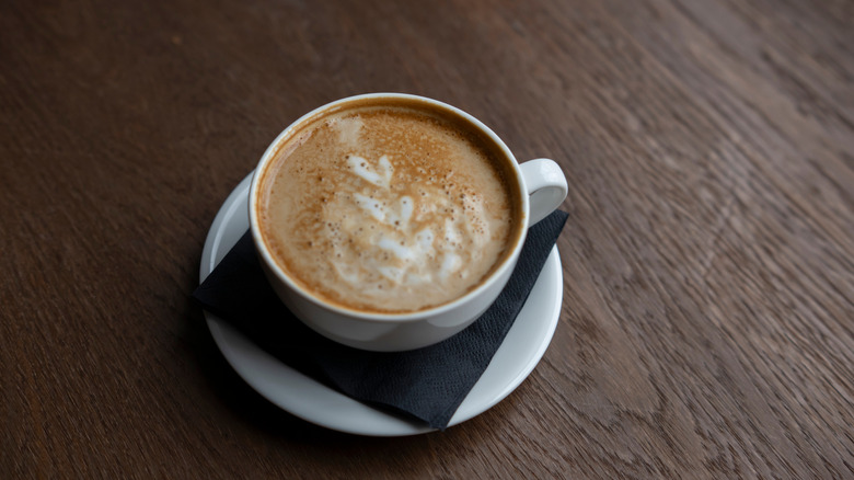 Oat milk curdled in coffee mug with black napkin