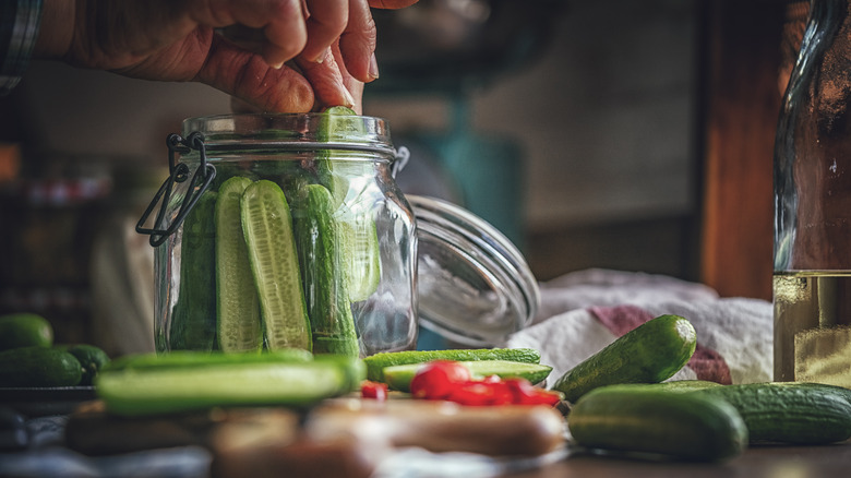 placing cucumbers in jar