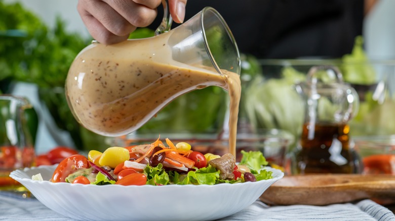 pouring dressing on salad