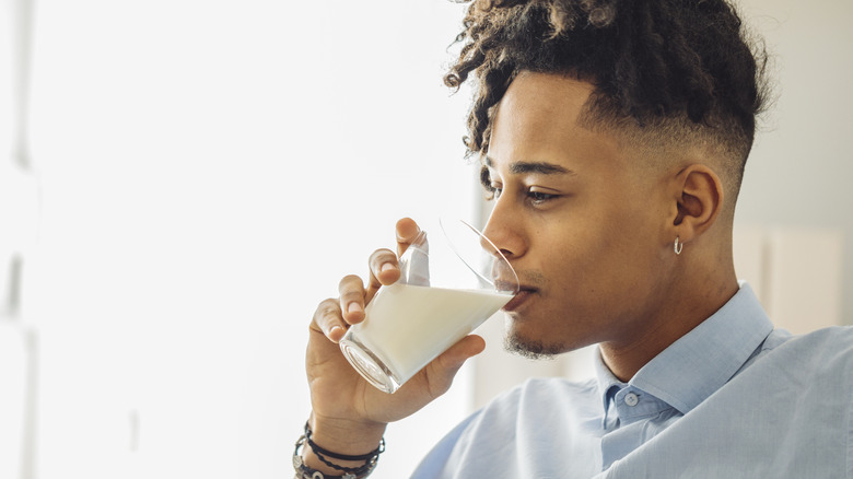 man drinks glass of milk