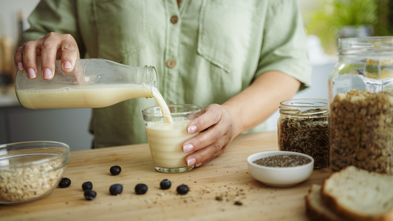 woman pours milk into glass