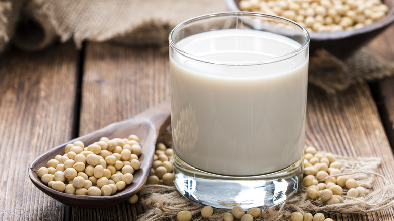 glass of milk surrounded by beans