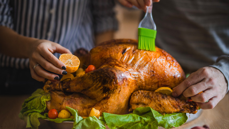 Person basting turkey with brush
