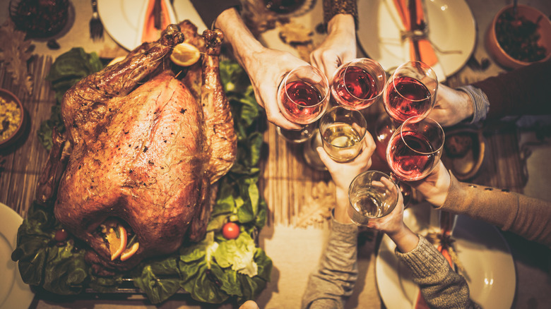 Friends toasting over whole turkey