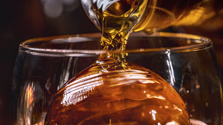 Whiskey poured over ice ball