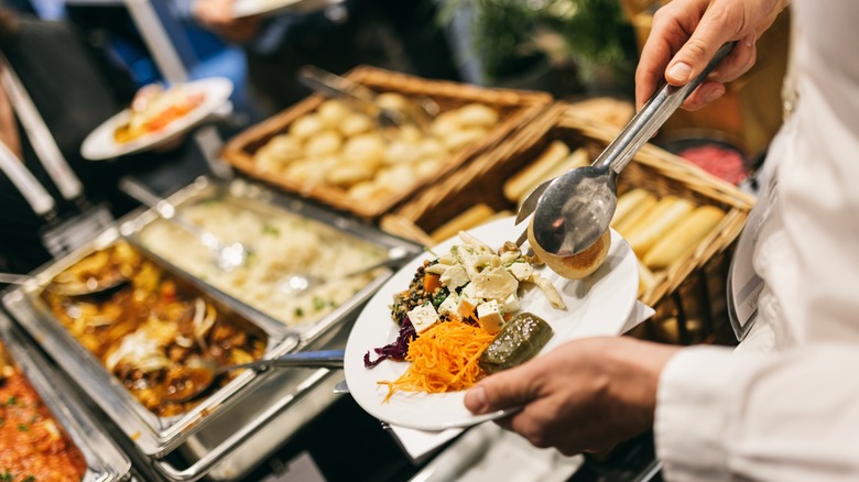 person putting food on plate