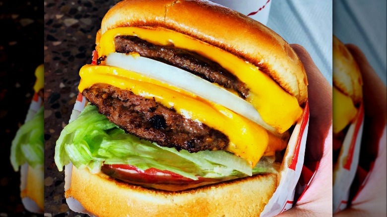 Person holding In-N-Out cheeseburger