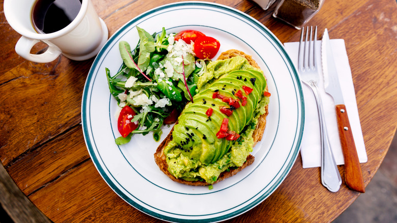 table with plate of avocado toast