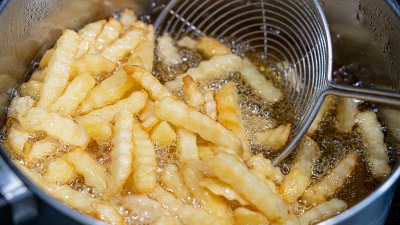 fries being scooped out of fryer