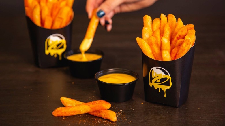 Taco Bell nacho fries with cheese sauce sit on a table.