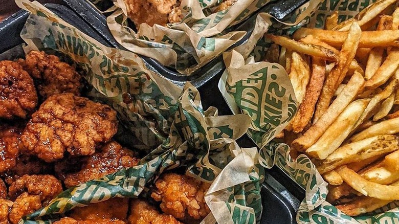 WingStop assorted chicken and fries are displayed in baskets.