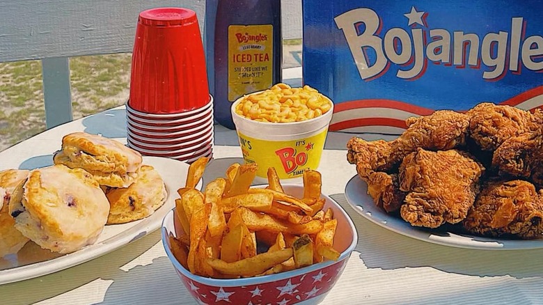 A Bojangles meal is displayed on an outdoor table with fries and chicken.