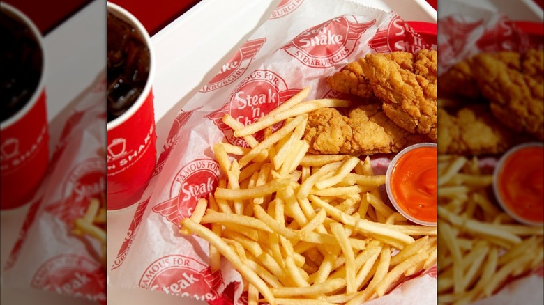 Steak 'n Shake fries, chiecken, and drink sit on a tray.