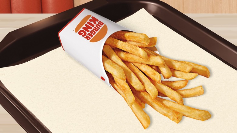 Burger King fries are spilling out of a box onto a tray.