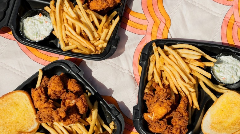 Three Hardee's meals with chicken tenders, toast, and coleslaw are served with fries.