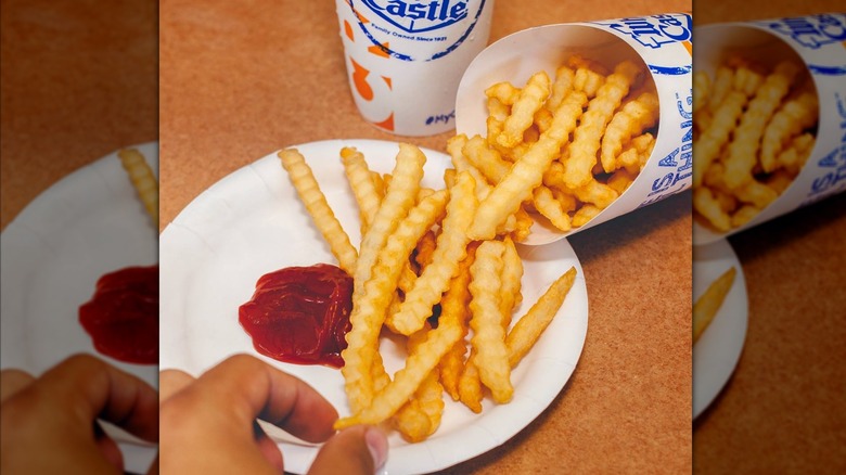 White Castle french fries are spread on a plate with ketchup.